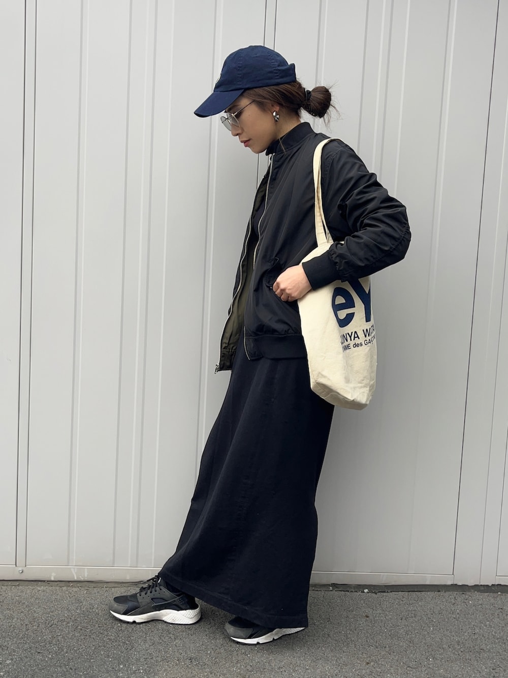 グリーン系のMA-1、ブラック系のスニーカー、グレー系のサングラスを着用したレディースの春コーディネートの3枚目の写真