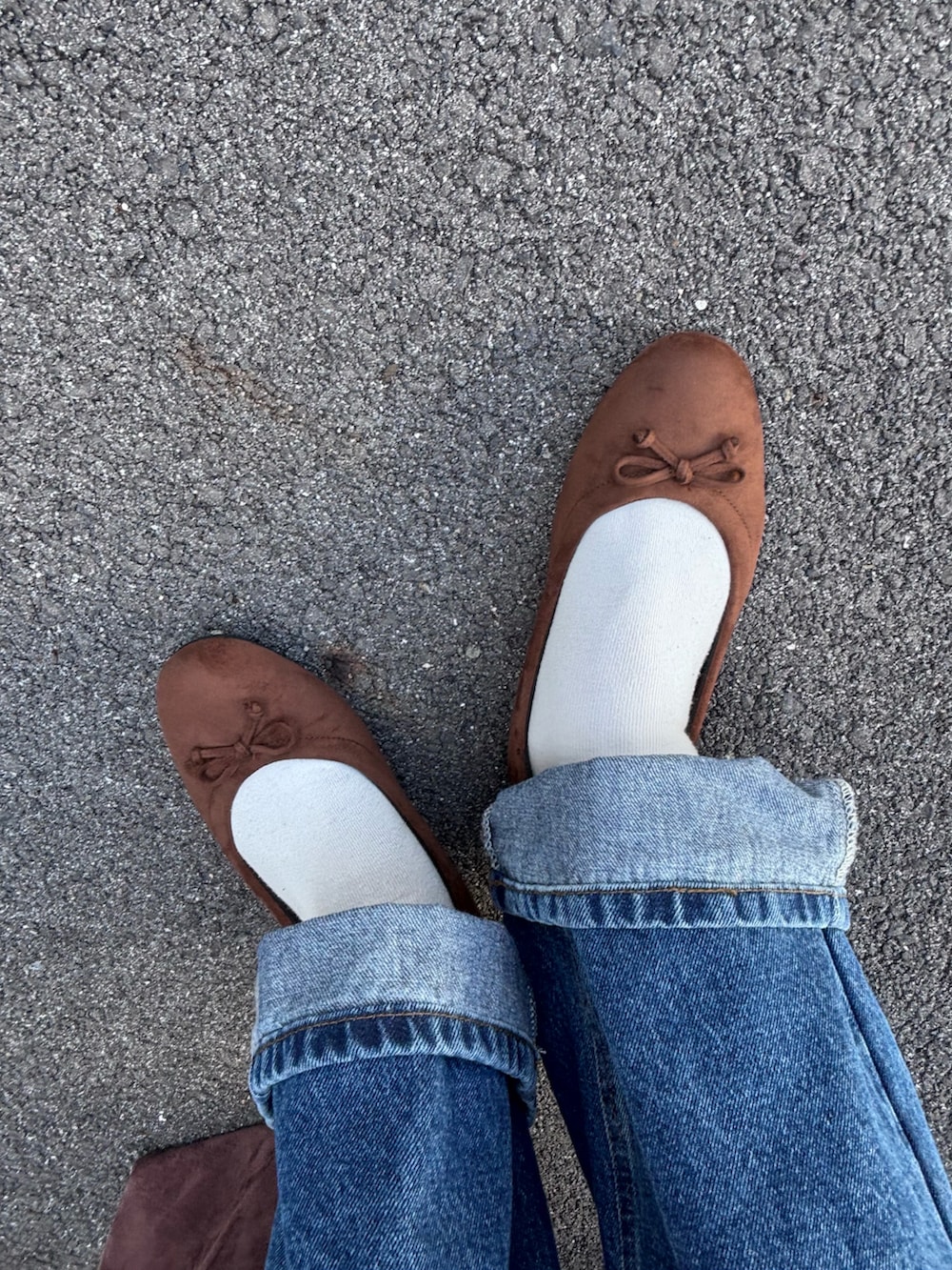 レッド系のニット/セーター、ブルー系のデニムパンツ、ブラウン系のパンプスを着用したレディースの秋コーディネートの5枚目の写真