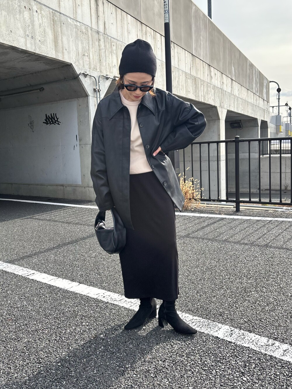 ブラック系のテーラードジャケット、ベージュ系のニット/セーターを着用したレディースの冬コーディネートの3枚目の写真