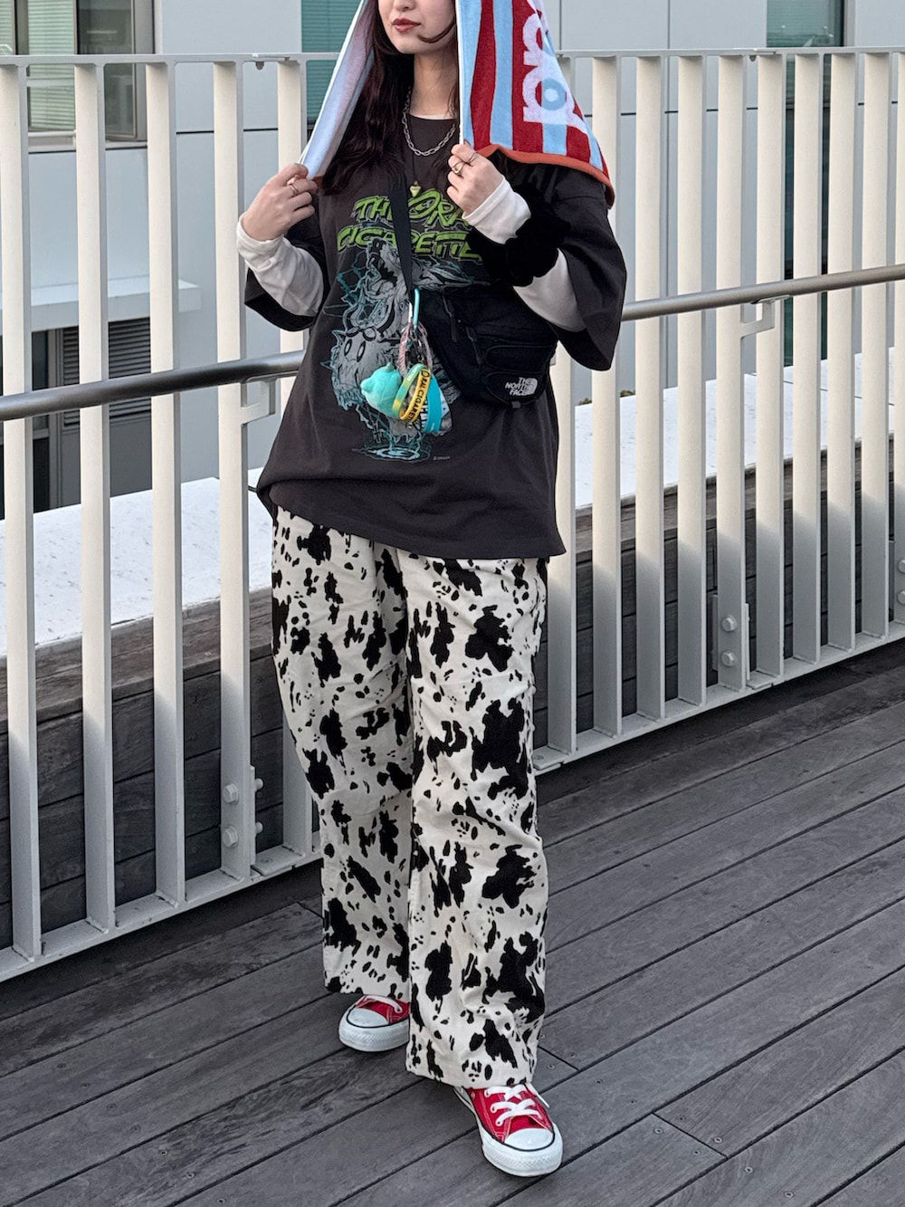 レッド系のスニーカー、ベージュ系のその他パンツ、ブラック系のボディバッグ/ウエストポーチを着用したレディースの春コーディネートの3枚目の写真