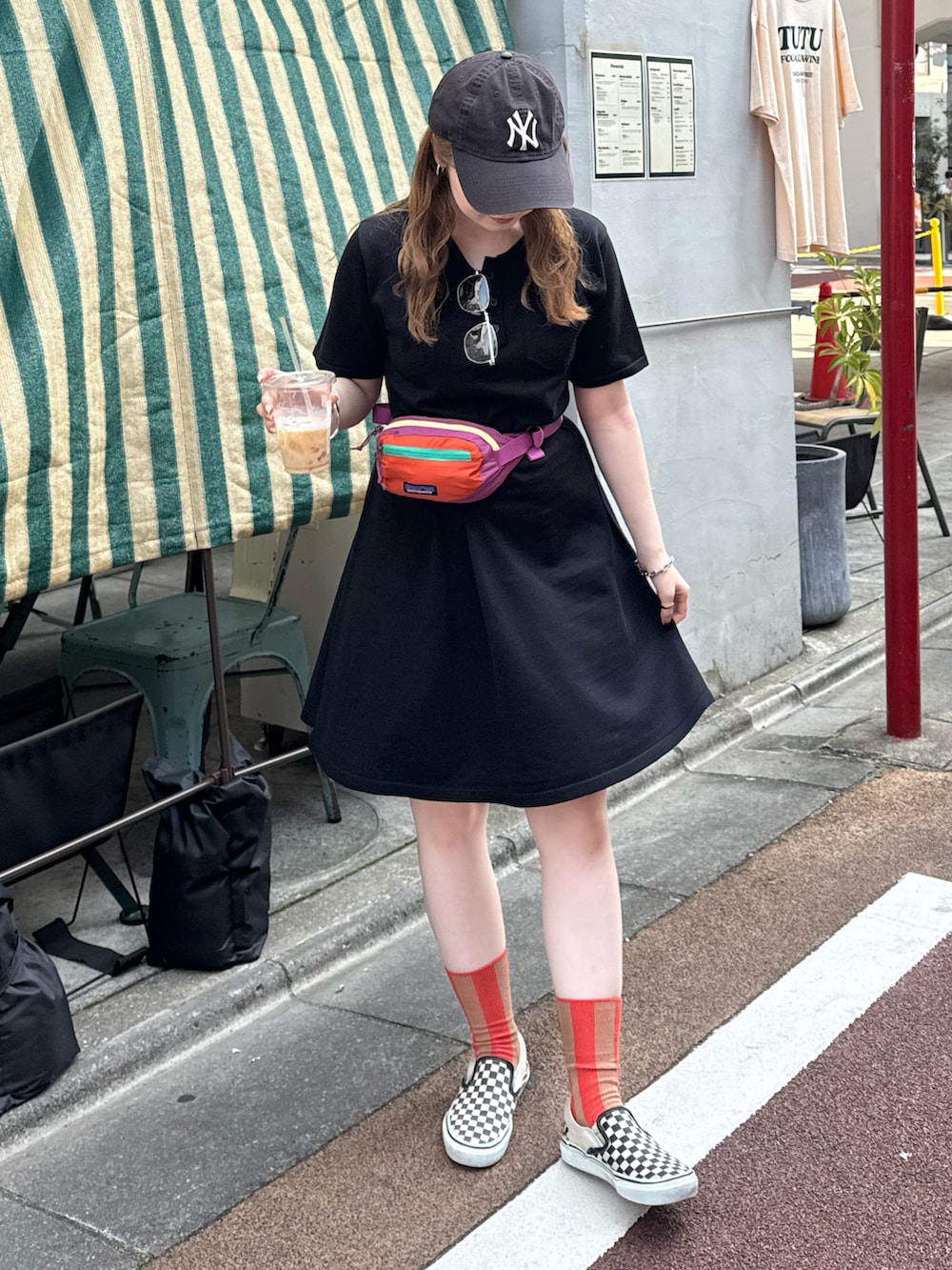 ブラック系のワンピース、ピンク系のボディバッグ/ウエストポーチ、ブラック系のスリッポンを着用したレディースの夏コーディネートの3枚目の写真