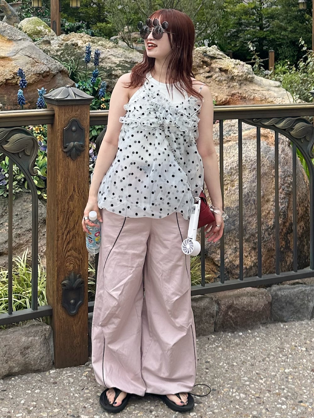 ピンク系のその他パンツ、ホワイト系のキャミソール、レッド系のショルダーバッグを着用したレディースの夏コーディネートの3枚目の写真