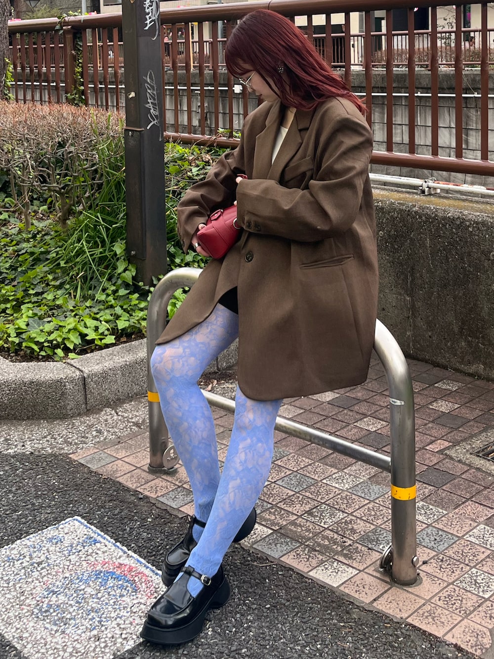 ブラウン系のテーラードジャケット、ホワイト系のキャミソール、ブラック系のローファーを着用したレディースの春コーディネートの5枚目の写真