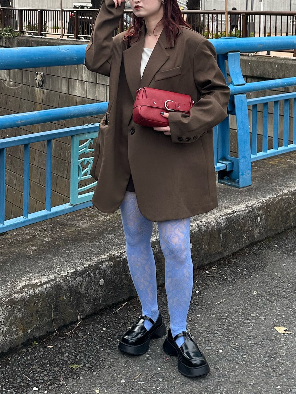 ブラウン系のテーラードジャケット、ホワイト系のキャミソール、ブラック系のローファーを着用したレディースの春コーディネートの3枚目の写真