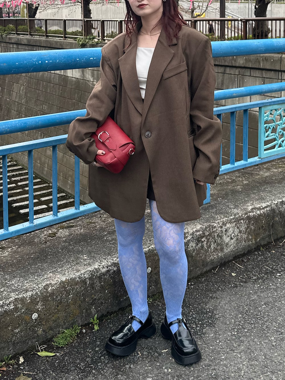 ブラウン系のテーラードジャケット、ホワイト系のキャミソール、ブラック系のローファーを着用したレディースの春コーディネートの4枚目の写真