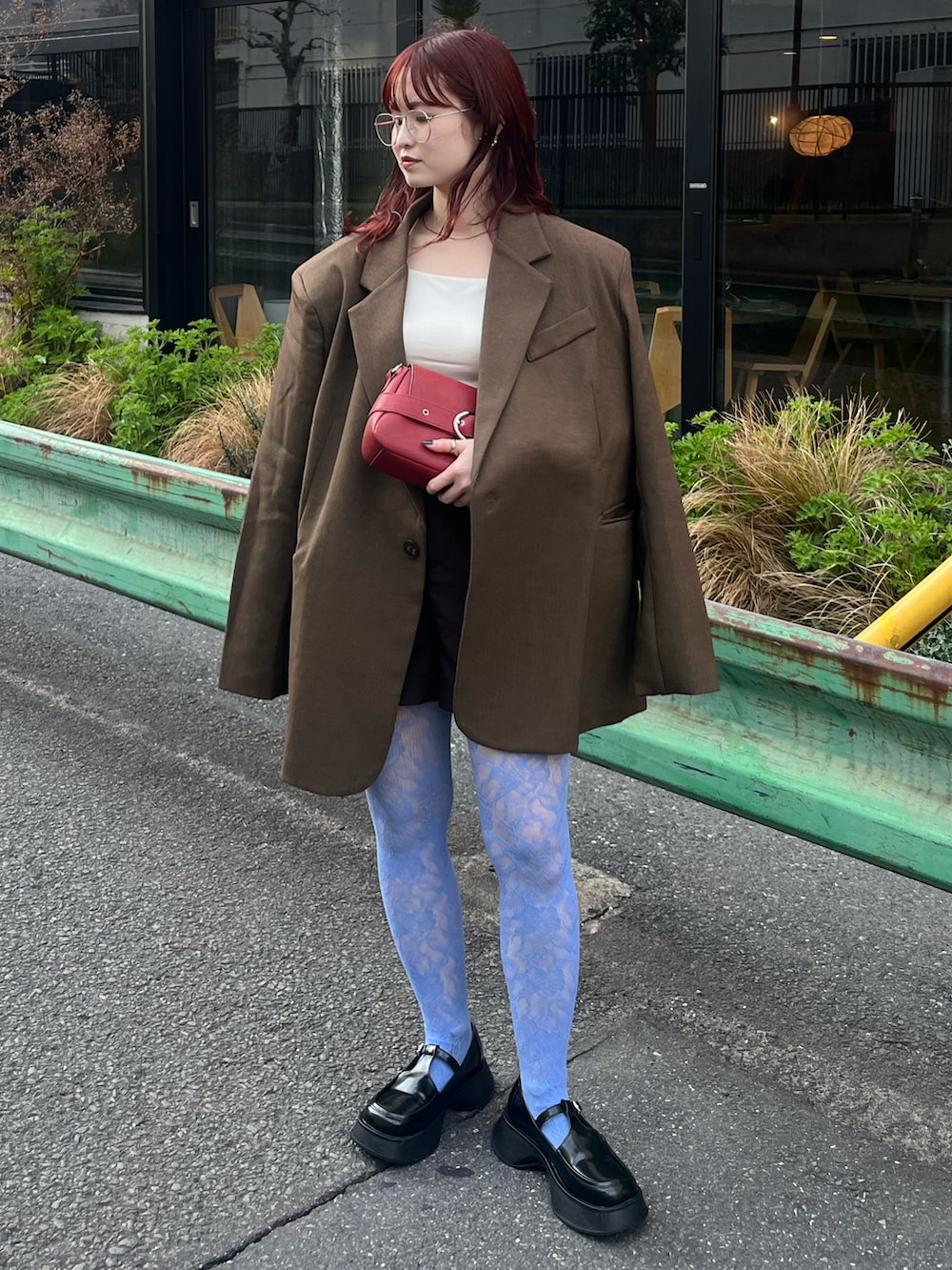 ブラウン系のテーラードジャケット、ホワイト系のキャミソール、ブラック系のローファーを着用したレディースの春コーディネートの2枚目の写真