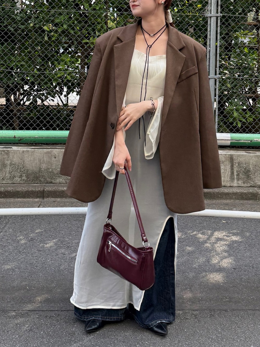 ホワイト系のキャミソール、レッド系のショルダーバッグ、ブラウン系のテーラードジャケットを着用したレディースの秋コーディネートの3枚目の写真