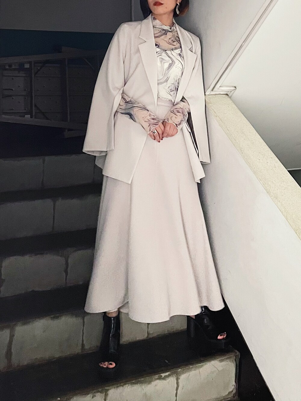 ベージュ系のテーラードジャケット、ブラック系のサンダル、ホワイト系のTシャツ/カットソーを着用したレディースの夏コーディネートの3枚目の写真