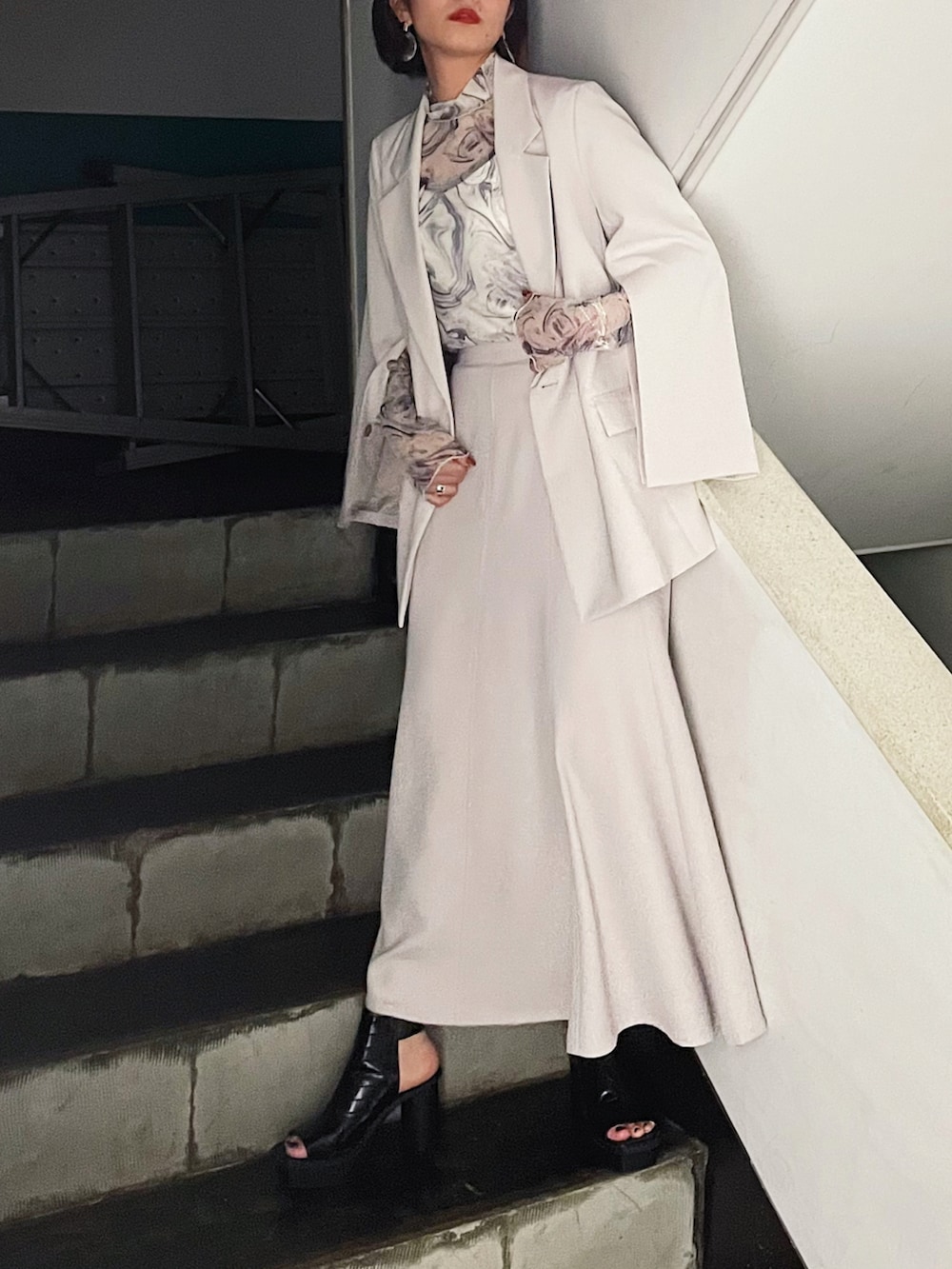 ベージュ系のテーラードジャケット、ブラック系のサンダル、ホワイト系のTシャツ/カットソーを着用したレディースの夏コーディネートの4枚目の写真