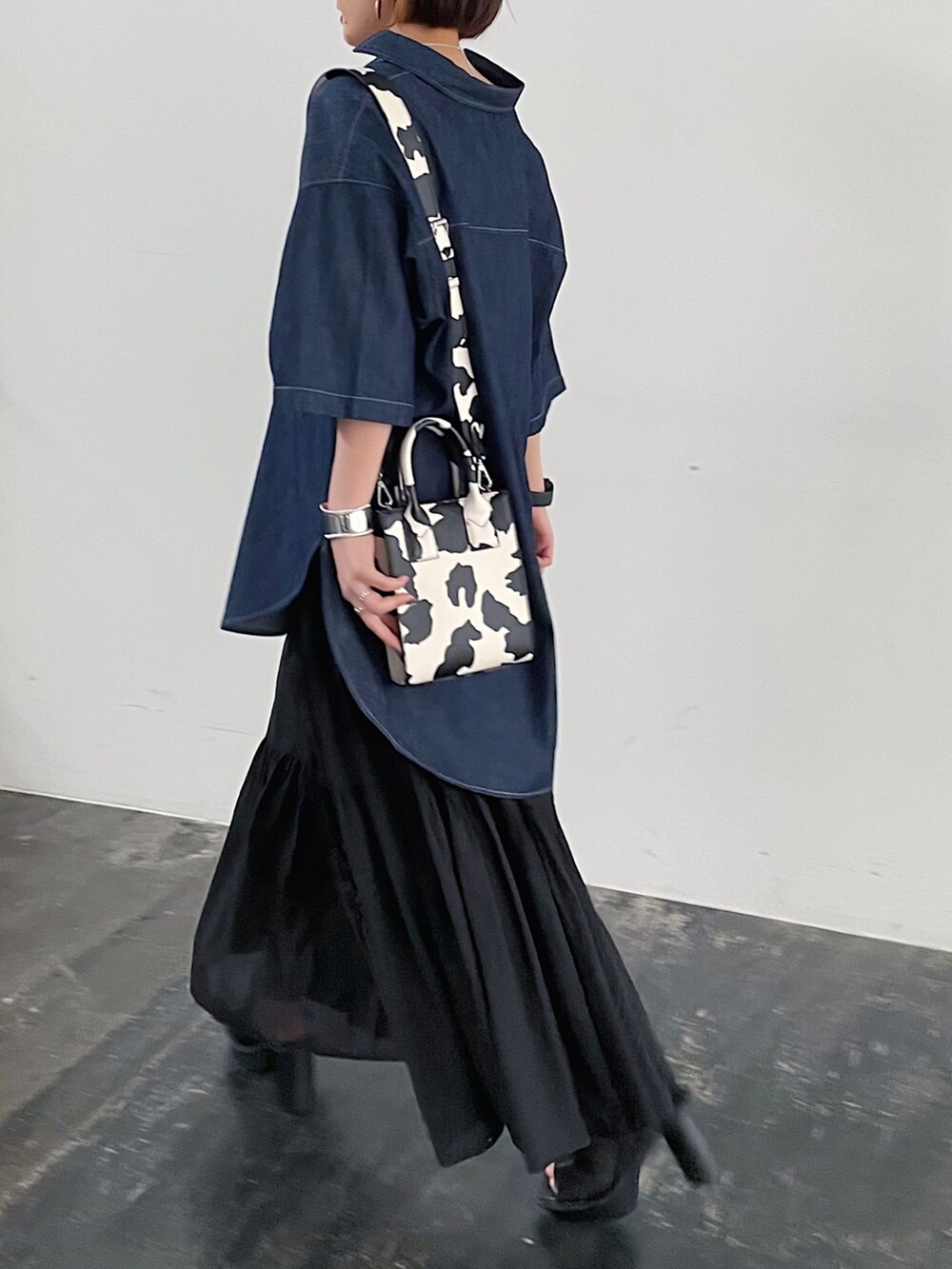 ブルー系のシャツ/ブラウス、ブラック系のスカート、ブラック系のサンダルを着用したレディースの春コーディネートの4枚目の写真