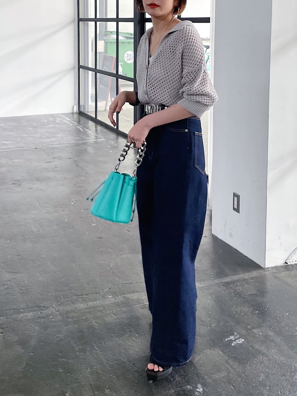 ベージュ系のニット/セーター、ブルー系のデニムパンツ、ブラック系のサンダルを着用したレディースの春コーディネートの3枚目の写真