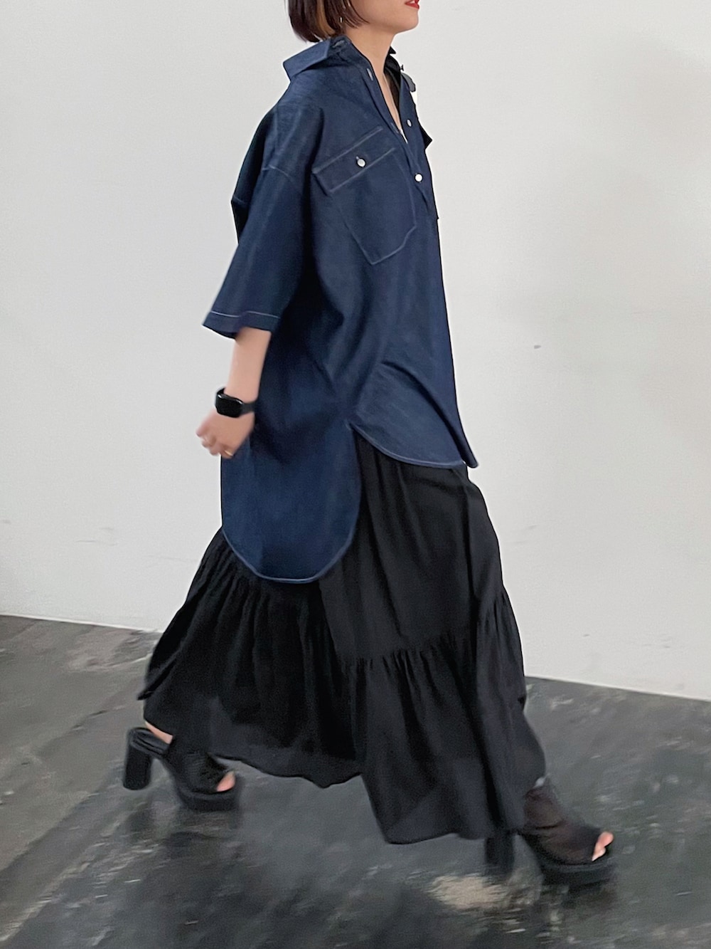 ブルー系のシャツ/ブラウス、ブラック系のスカート、ブラック系のサンダルを着用したレディースの春コーディネートの2枚目の写真