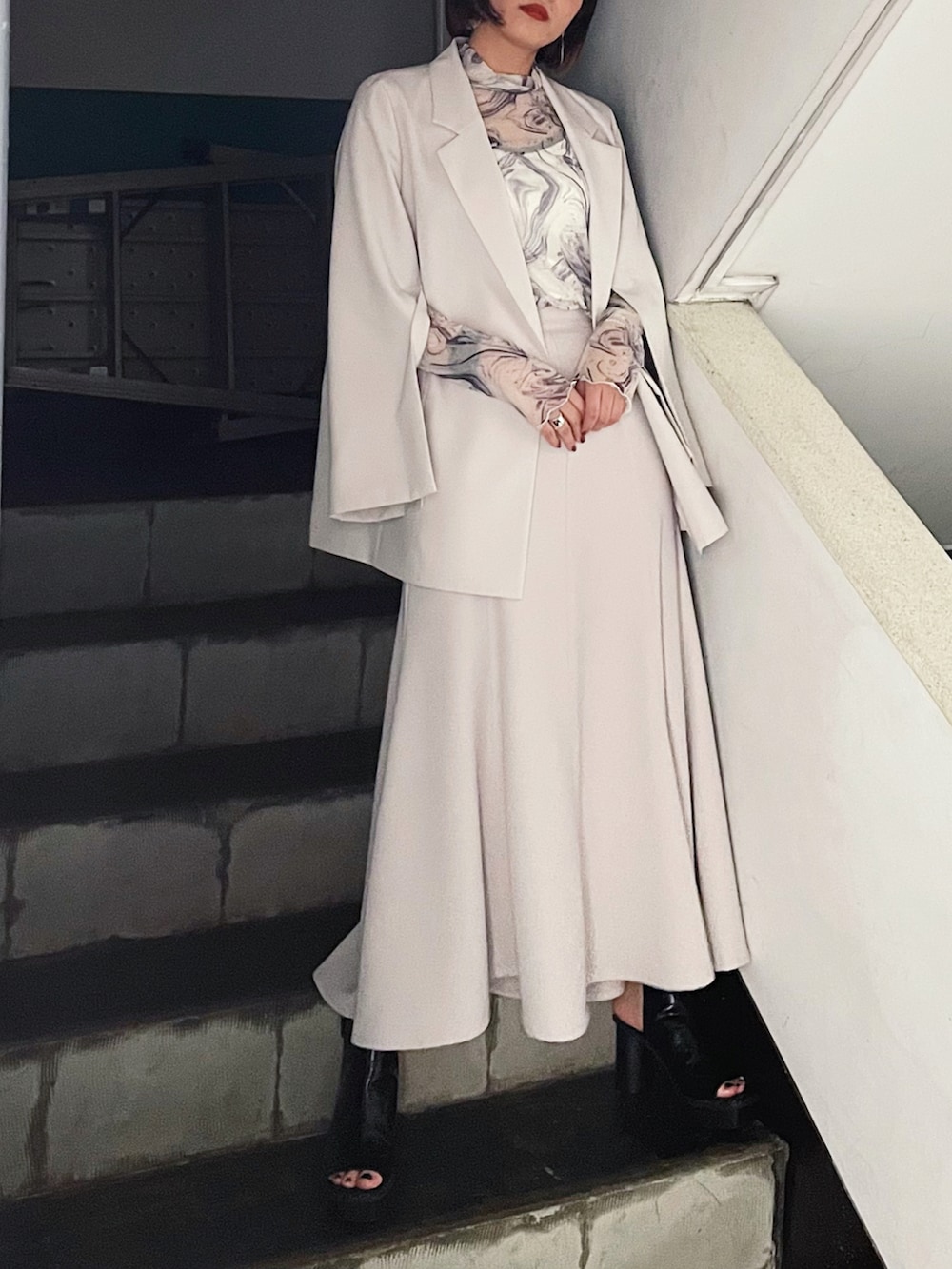 ベージュ系のテーラードジャケット、ブラック系のサンダル、ホワイト系のTシャツ/カットソーを着用したレディースの夏コーディネートの2枚目の写真