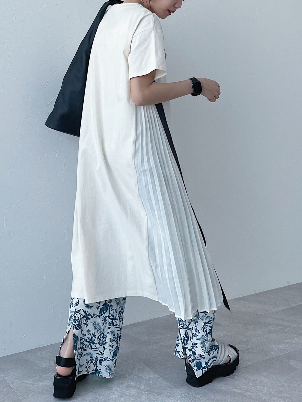 ブラック系のトートバッグ、ホワイト系のワンピース、シルバー系のサンダルを着用したレディースの春コーディネートの2枚目の写真