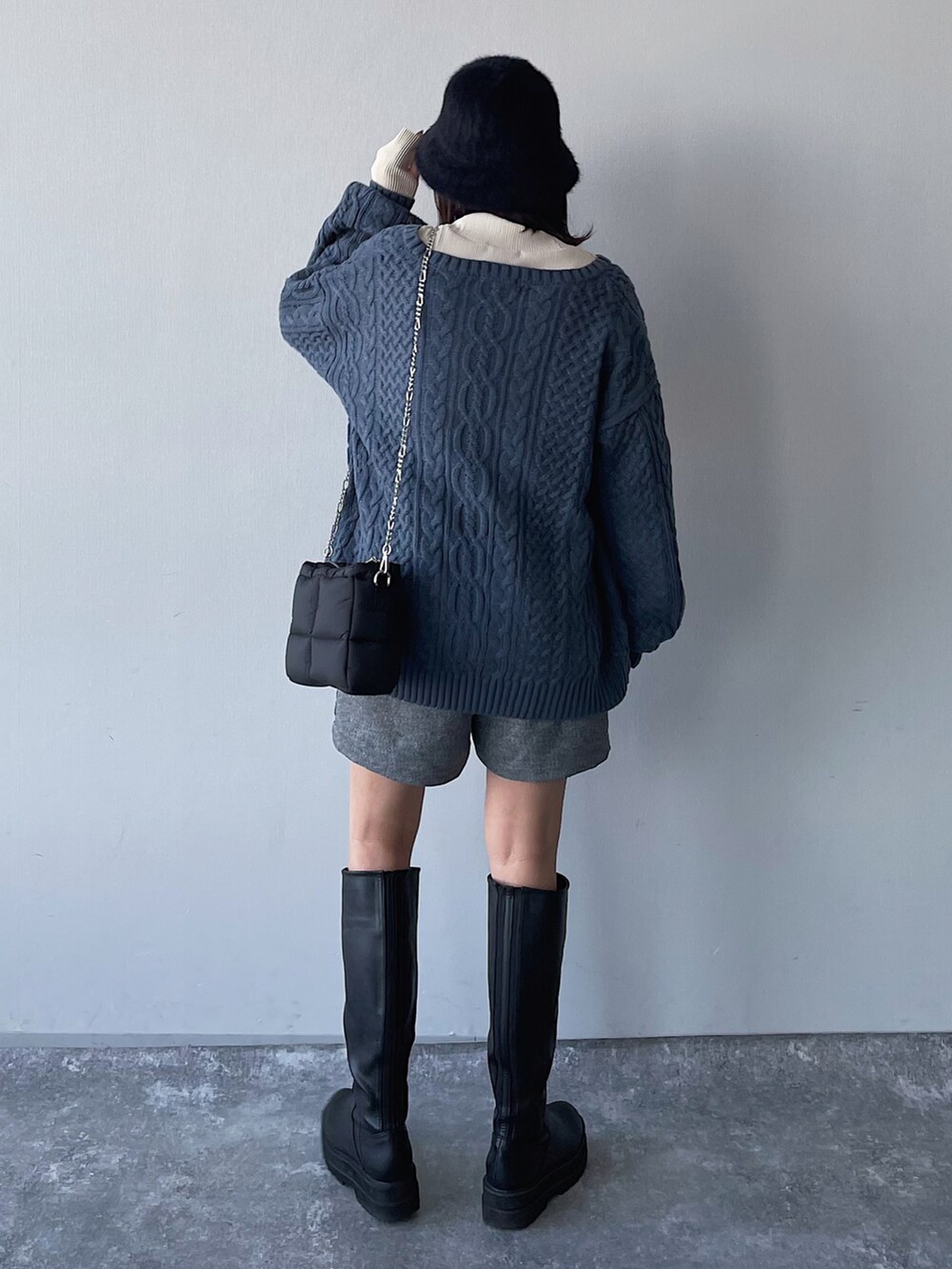 ブルー系のニット/セーター、グレー系のパンツ、ブラック系のブーツを着用したレディースの冬コーディネートの3枚目の写真