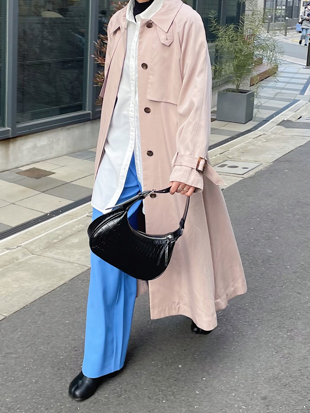 ベージュ系のトレンチコート、ホワイト系のシャツ/ブラウス、ブルー系のスラックスを着用したレディースの冬コーディネートの4枚目の写真