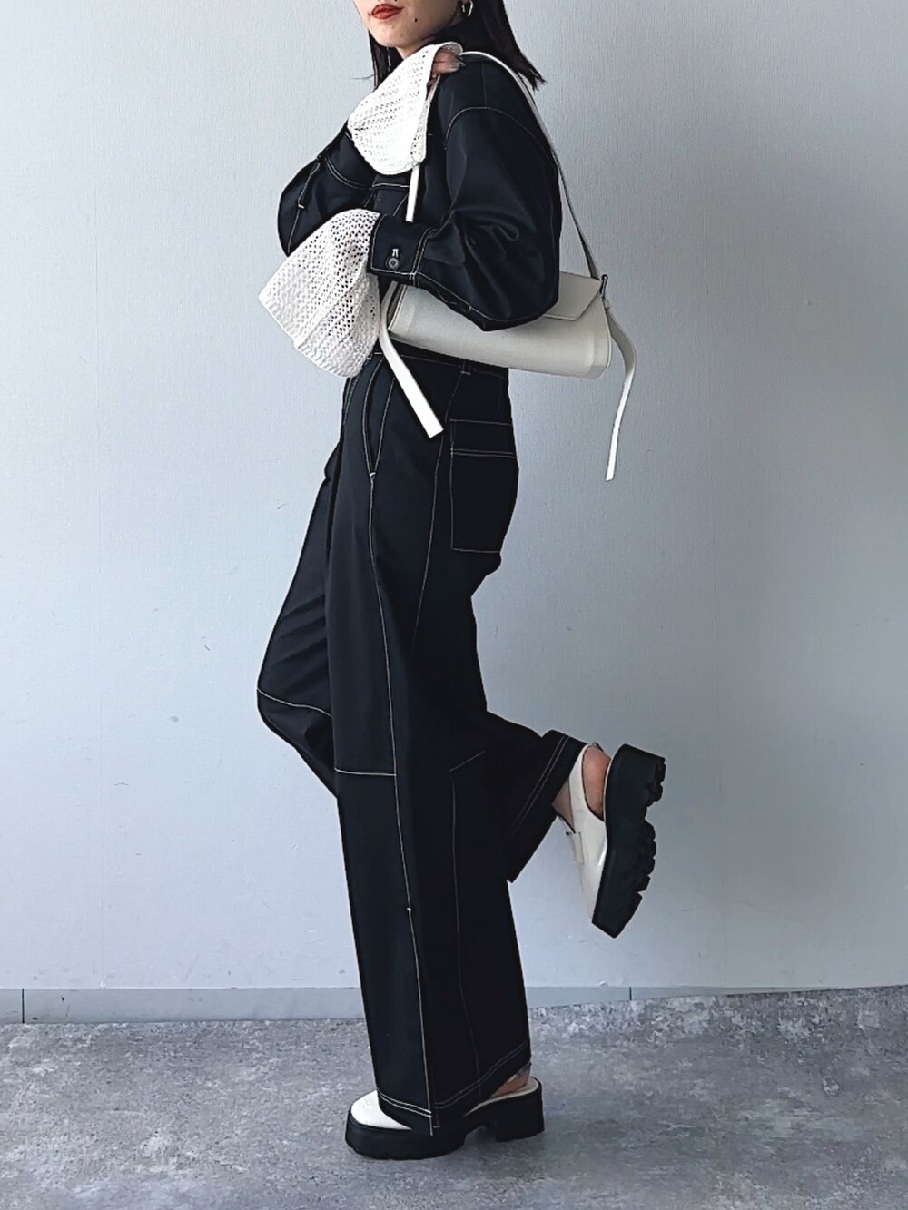 ブラック系のシャツ/ブラウス、ブラック系のスラックス、ホワイト系のニット/セーターを着用したレディースの冬コーディネートの3枚目の写真