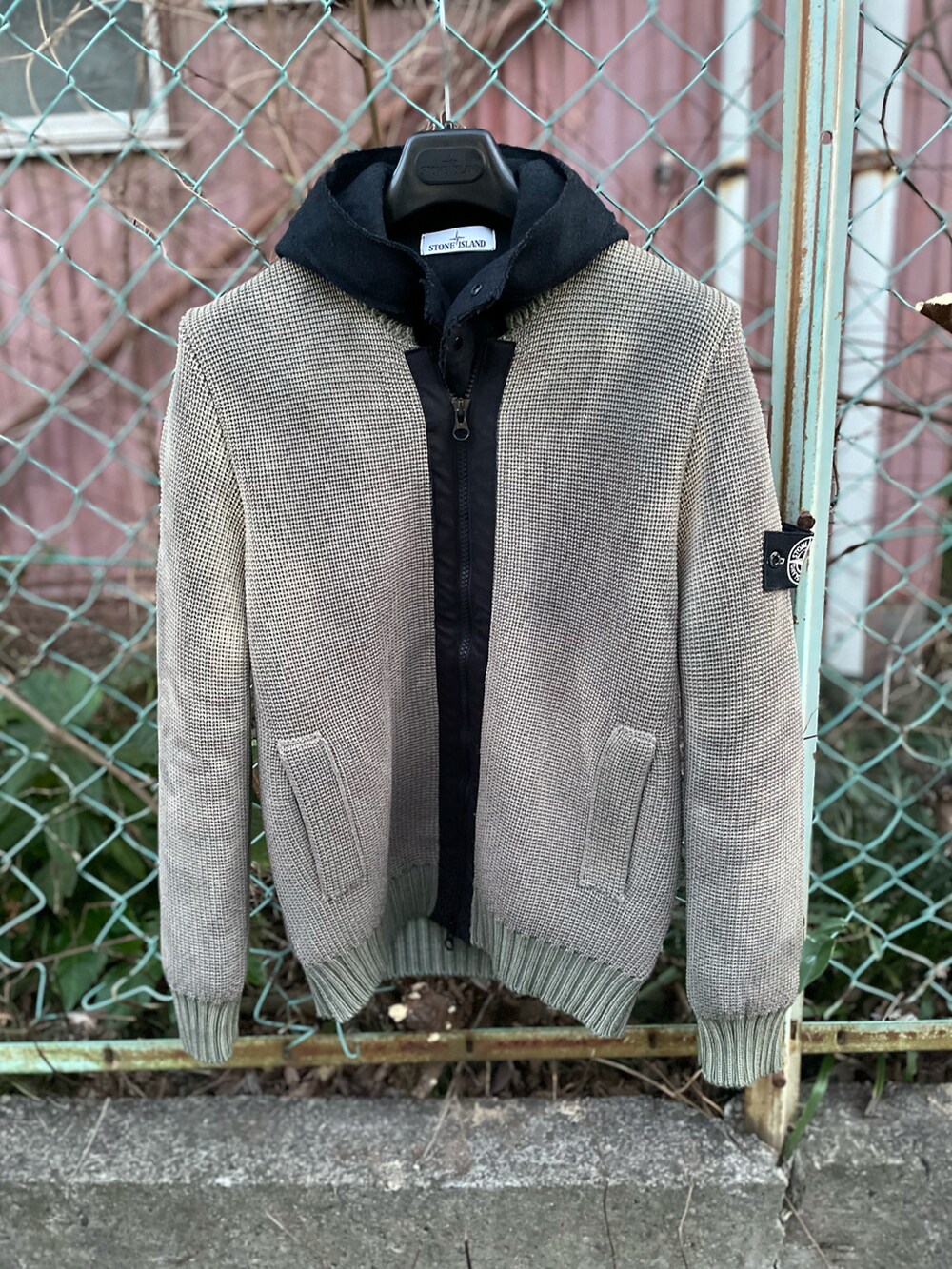 グレー系のニット/セーター、ブラック系のその他パンツ、グレー系のスニーカーを着用したメンズの冬コーディネートの2枚目の写真