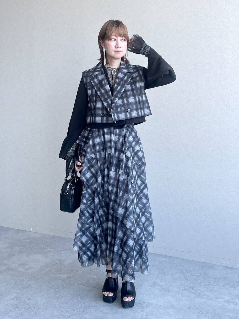 ブラック系のTシャツ/カットソー、ブラック系のテーラードジャケット、ブラック系のショルダーバッグを着用したレディースの春コーディネートの3枚目の写真