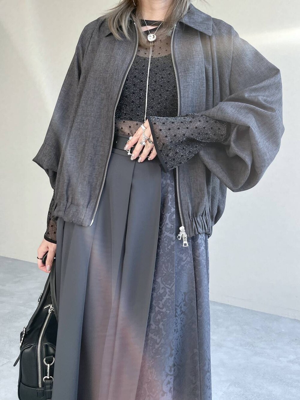 ブラック系のTシャツ/カットソー、ブラック系のボストンバッグ、ブラック系のブーツを着用したレディースの秋コーディネートの5枚目の写真