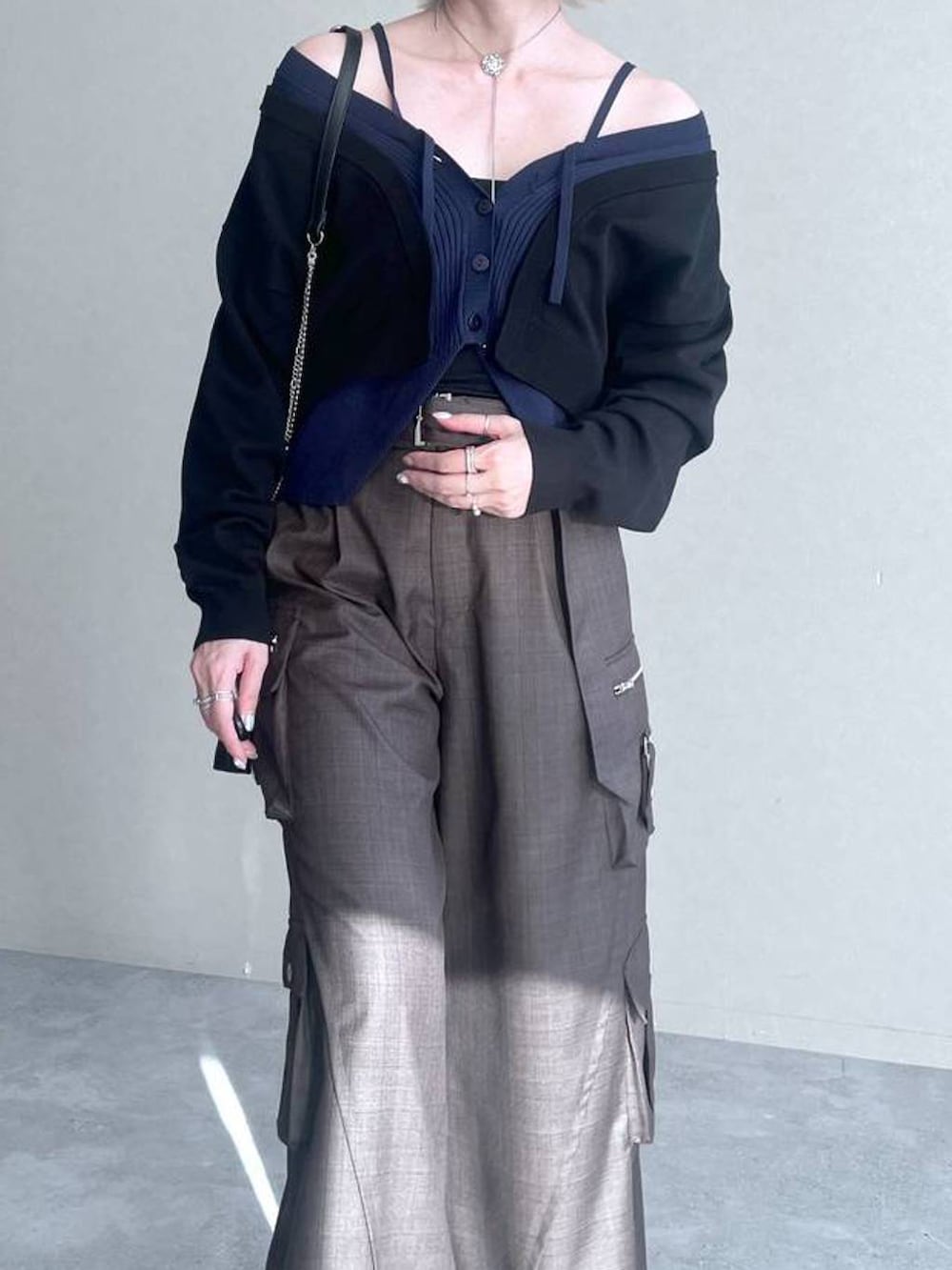 ブラック系のカーディガン/ボレロ、ブラウン系のカーゴパンツ、シルバー系のネックレスを着用したレディースの夏コーディネートの4枚目の写真