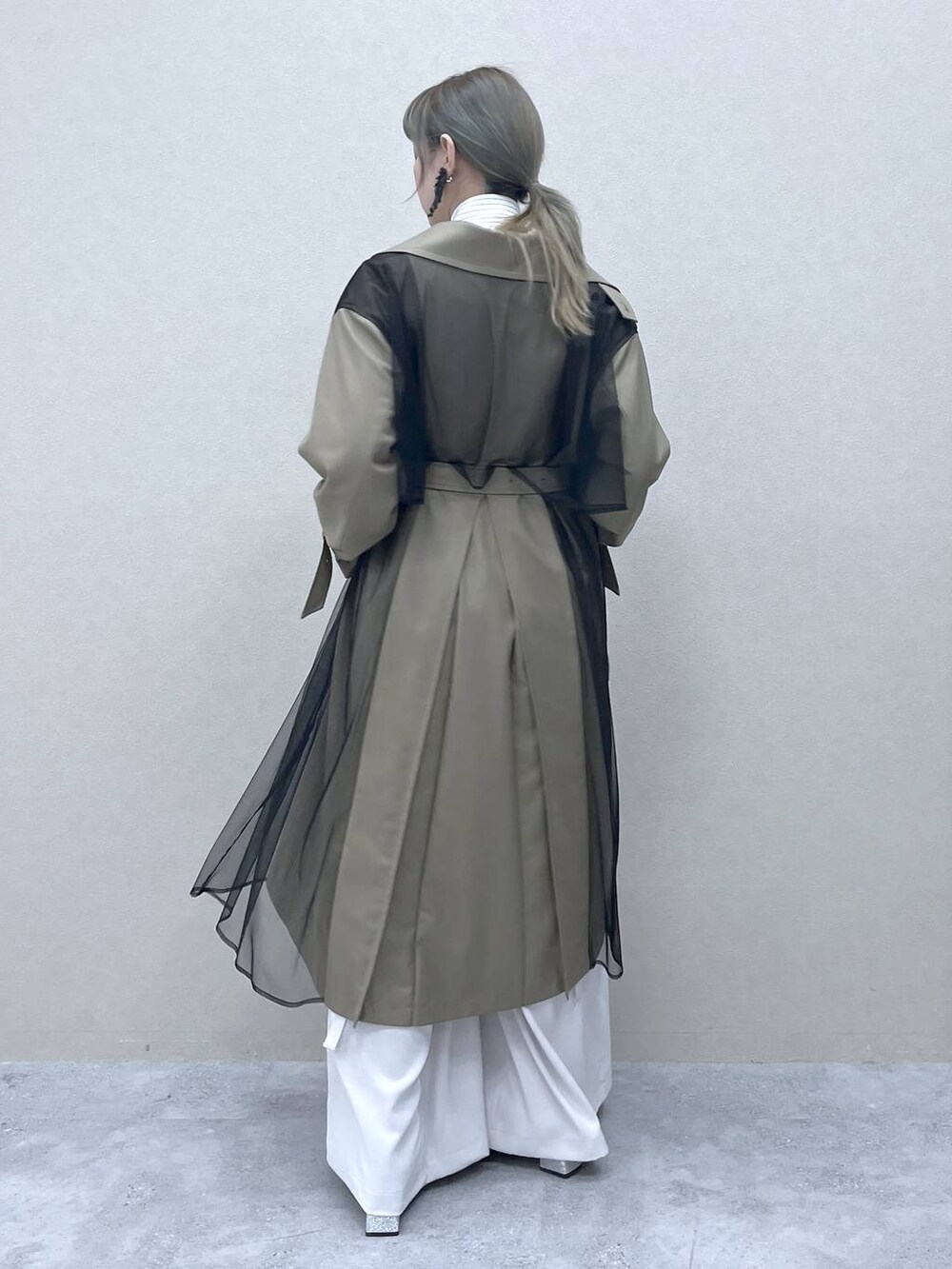 ベージュ系のトレンチコート、ブラック系のショルダーバッグ、ホワイト系のシャツ/ブラウスを着用したレディースの冬コーディネートの4枚目の写真