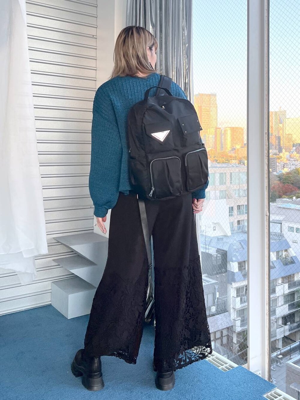 ブラック系のブーツ、ブルー系のニット/セーター、ブラック系のその他パンツを着用したレディースの冬コーディネートの8枚目の写真