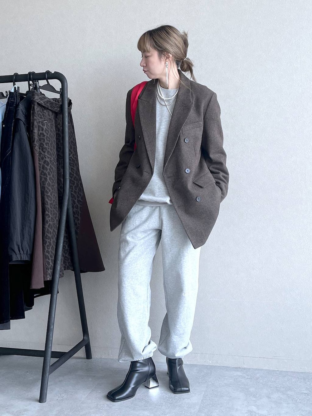 ブラック系のブーツ、レッド系のトートバッグ、グレー系のその他パンツを着用したレディースの冬コーディネートの6枚目の写真