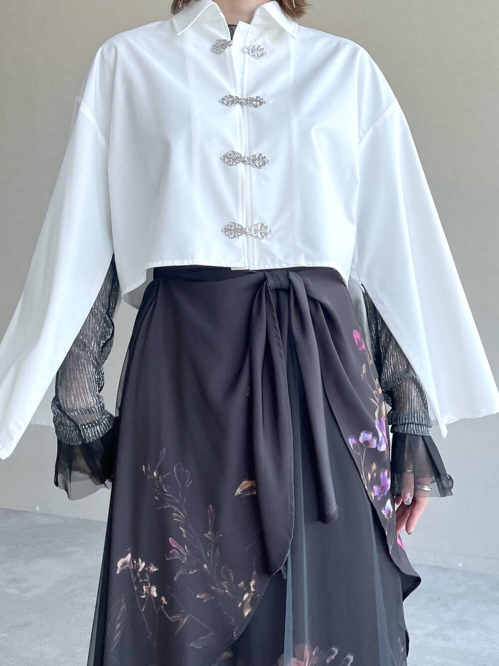 ブラック系のスカート、ブラック系のTシャツ/カットソー、ホワイト系のシャツ/ブラウスを着用したレディースの春コーディネートの3枚目の写真