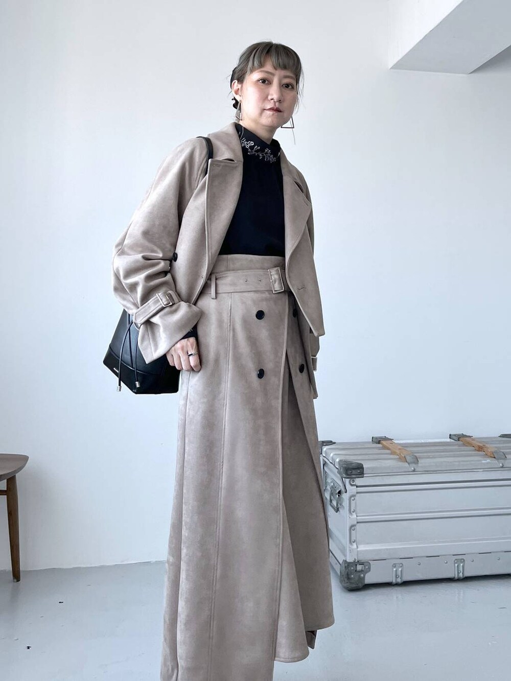 グレー系のブーツ、ブラック系のショルダーバッグ、ベージュ系のトレンチコートを着用したレディースの夏コーディネートの9枚目の写真