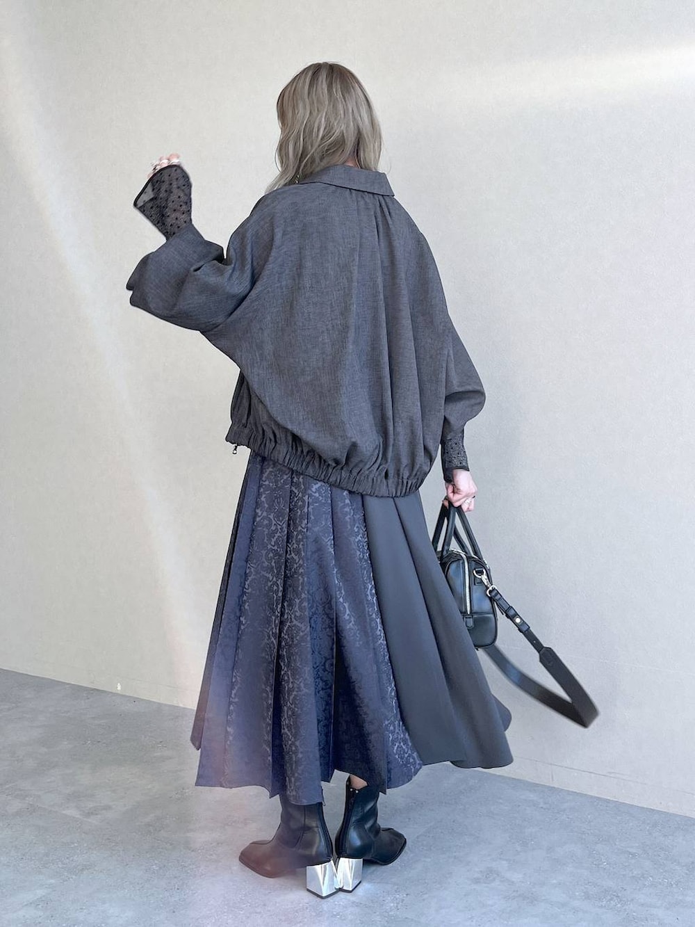 ブラック系のTシャツ/カットソー、ブラック系のボストンバッグ、ブラック系のブーツを着用したレディースの秋コーディネートの8枚目の写真