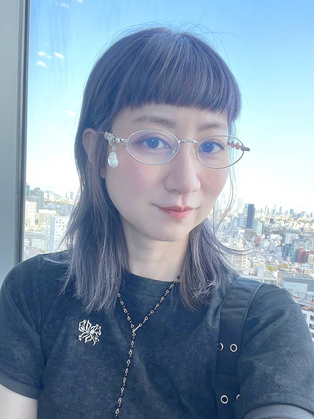 ブラック系のTシャツ/カットソー、ブラック系のネックレス、シルバー系のメガネを着用したレディースの春コーディネートの5枚目の写真