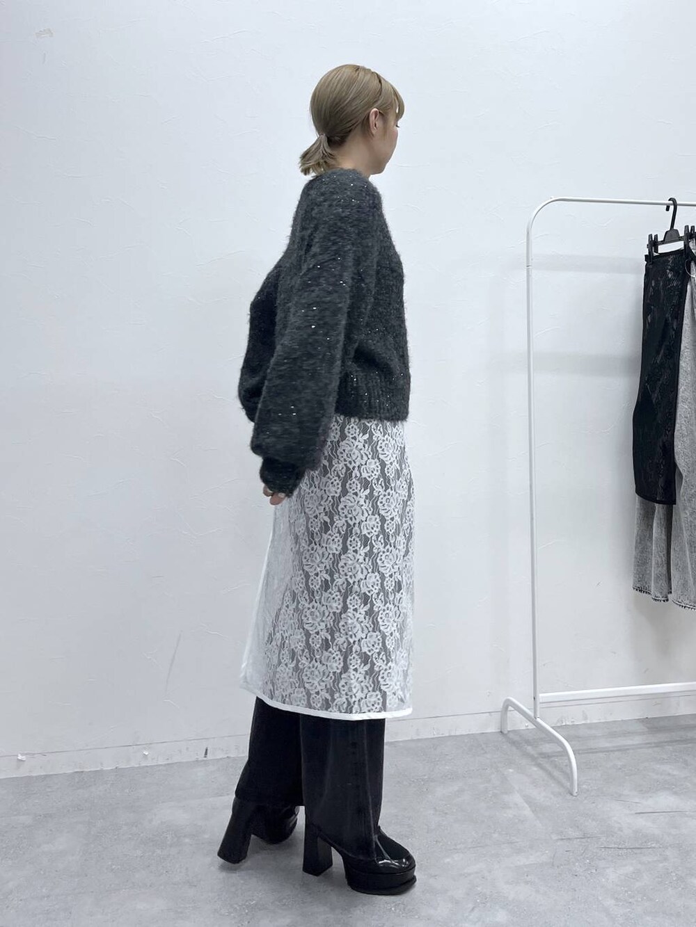 ブラック系のブーツ、グレー系のニット/セーター、ブラック系のデニムパンツを着用したレディースの秋コーディネートの6枚目の写真