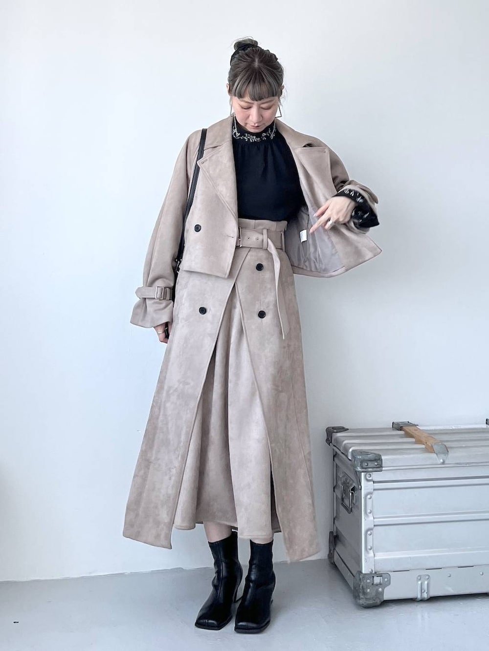 グレー系のブーツ、ブラック系のショルダーバッグ、ベージュ系のトレンチコートを着用したレディースの夏コーディネートの8枚目の写真