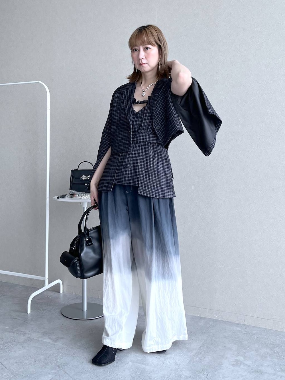 ブラック系のブーツ、ブラック系のボストンバッグ、ブラック系のその他パンツを着用したレディースの冬コーディネートの8枚目の写真