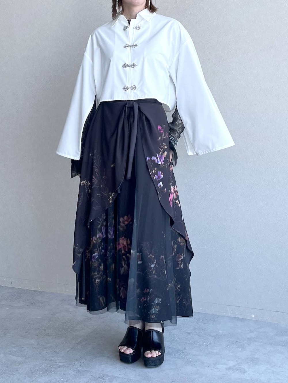 ブラック系のスカート、ブラック系のTシャツ/カットソー、ホワイト系のシャツ/ブラウスを着用したレディースの春コーディネートの5枚目の写真