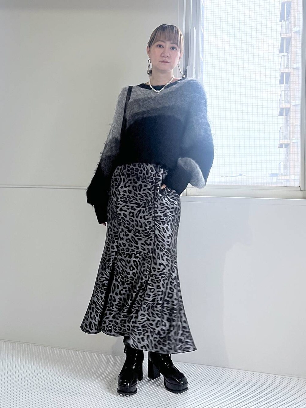 ブラック系のブーツ、ブラック系のショルダーバッグ、ブラック系のニット/セーターを着用したレディースの秋コーディネートの2枚目の写真