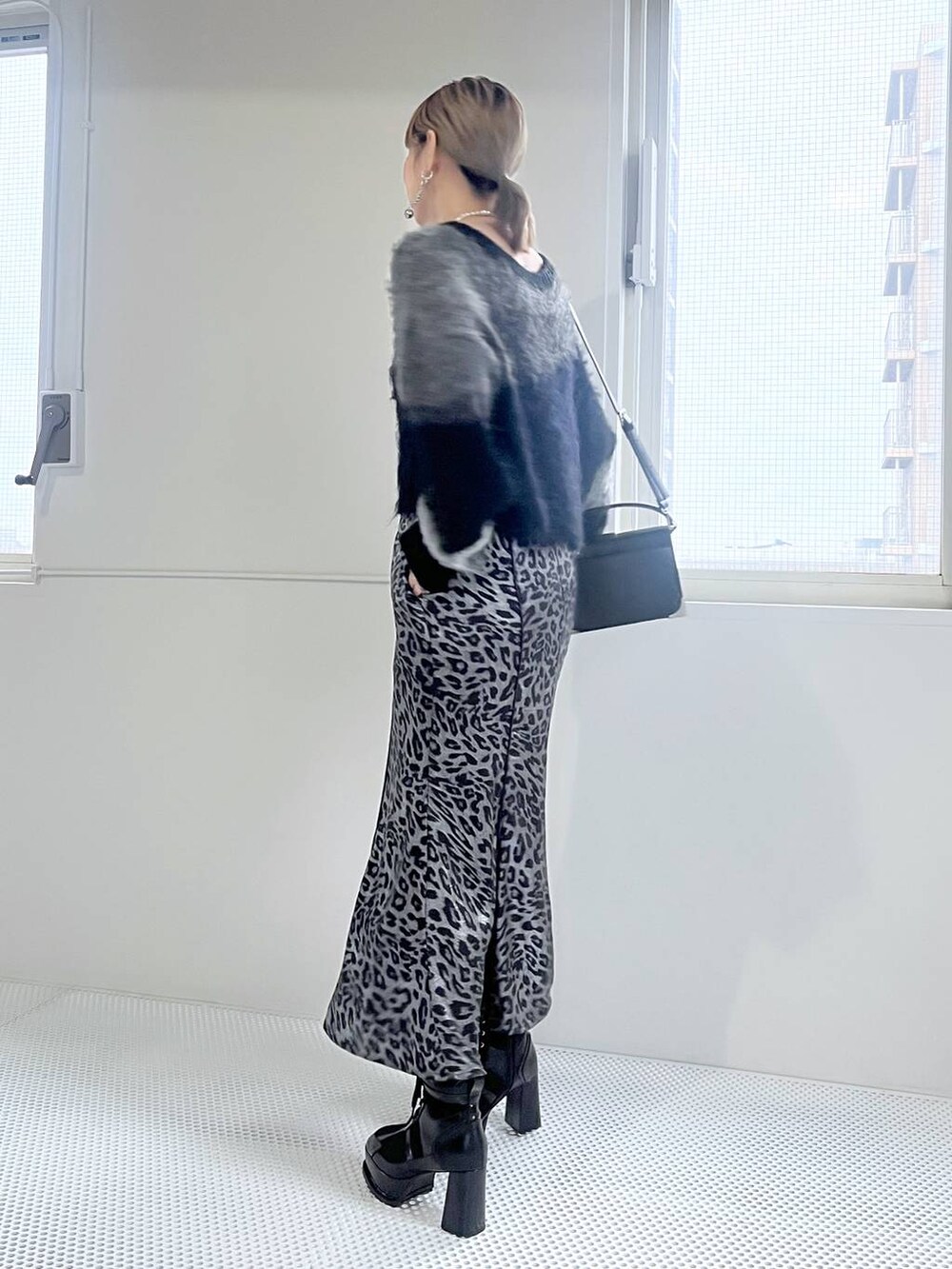 ブラック系のブーツ、ブラック系のショルダーバッグ、ブラック系のニット/セーターを着用したレディースの秋コーディネートの3枚目の写真