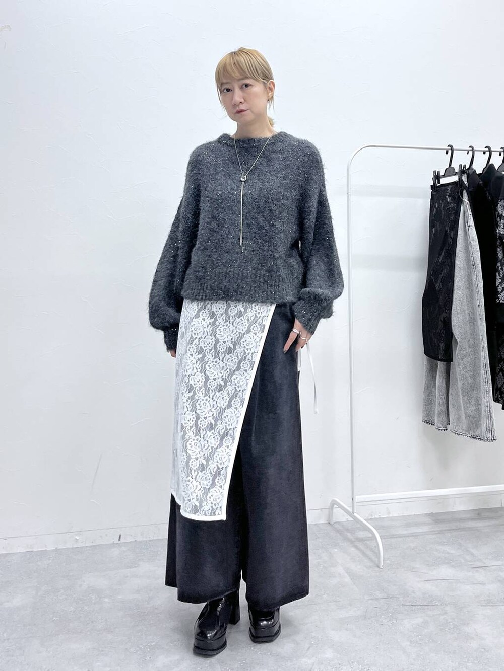 ブラック系のブーツ、グレー系のニット/セーター、ブラック系のデニムパンツを着用したレディースの秋コーディネートの7枚目の写真