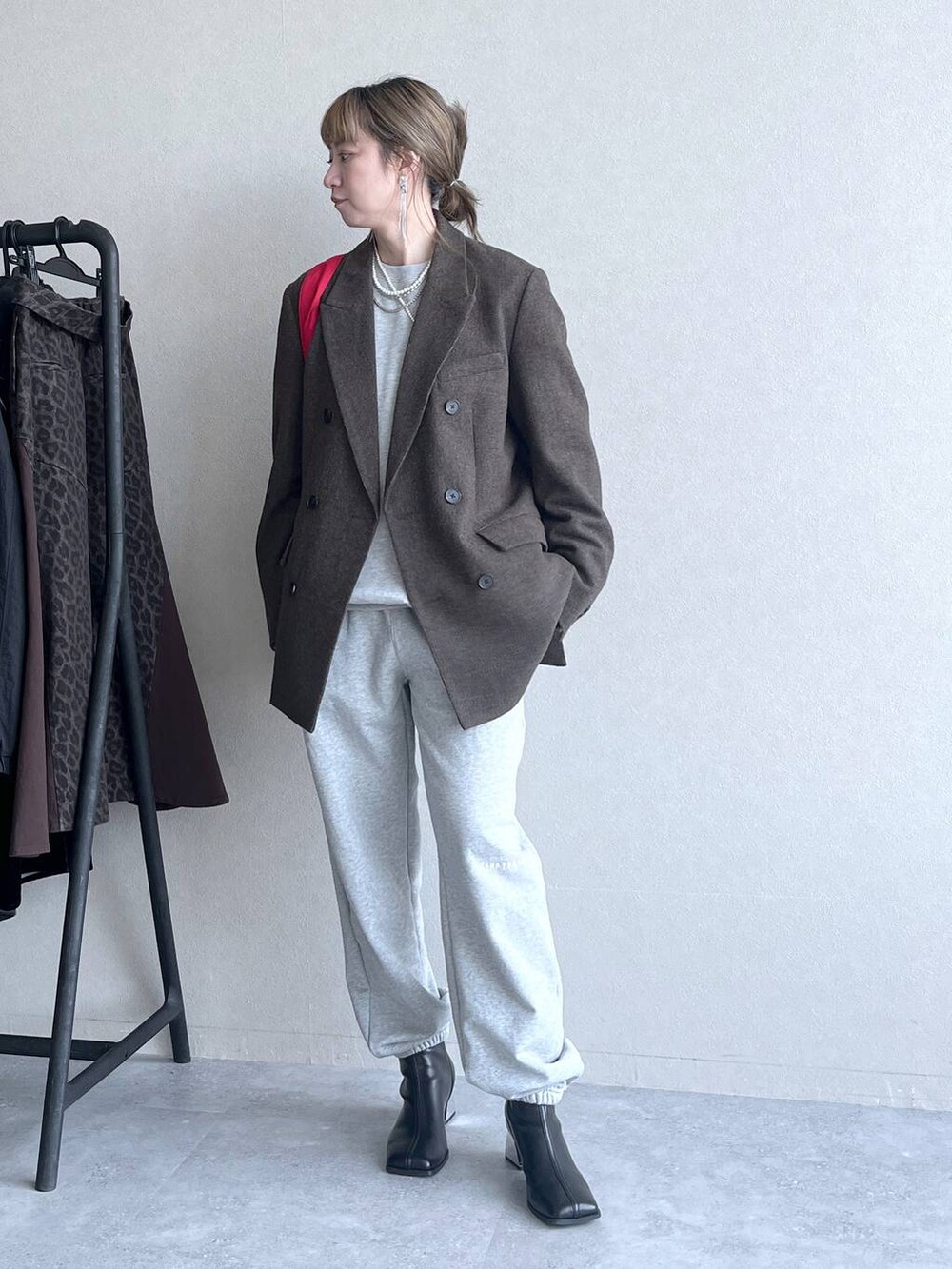 ブラック系のブーツ、レッド系のトートバッグ、グレー系のその他パンツを着用したレディースの冬コーディネートの9枚目の写真