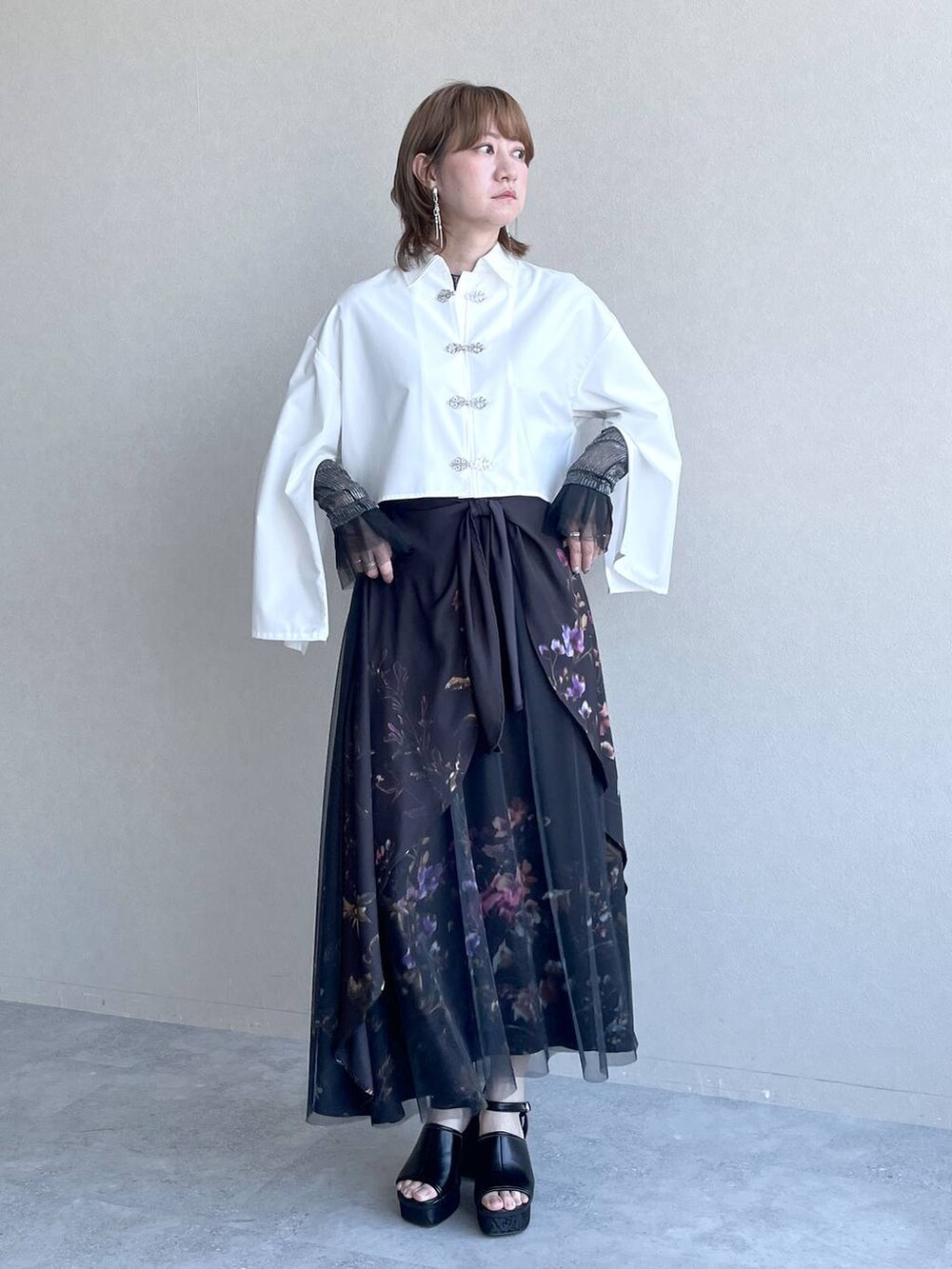 ブラック系のスカート、ブラック系のTシャツ/カットソー、ホワイト系のシャツ/ブラウスを着用したレディースの春コーディネートの7枚目の写真