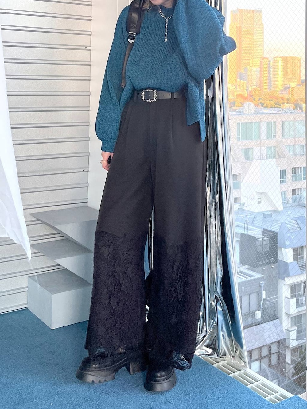 ブラック系のブーツ、ブルー系のニット/セーター、ブラック系のその他パンツを着用したレディースの冬コーディネートの6枚目の写真