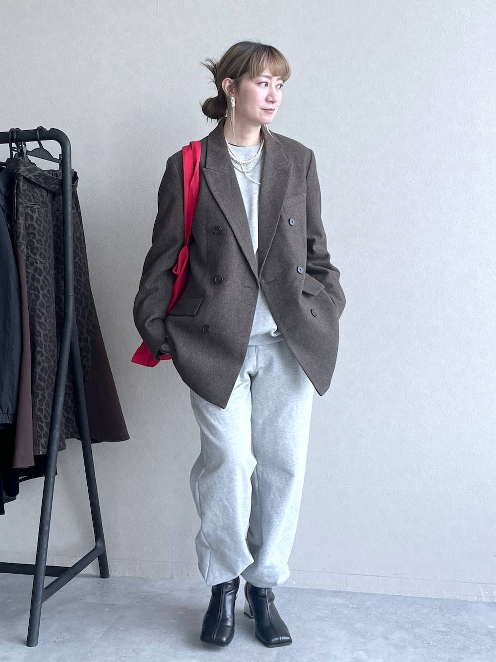 ブラック系のブーツ、レッド系のトートバッグ、グレー系のその他パンツを着用したレディースの冬コーディネートの2枚目の写真