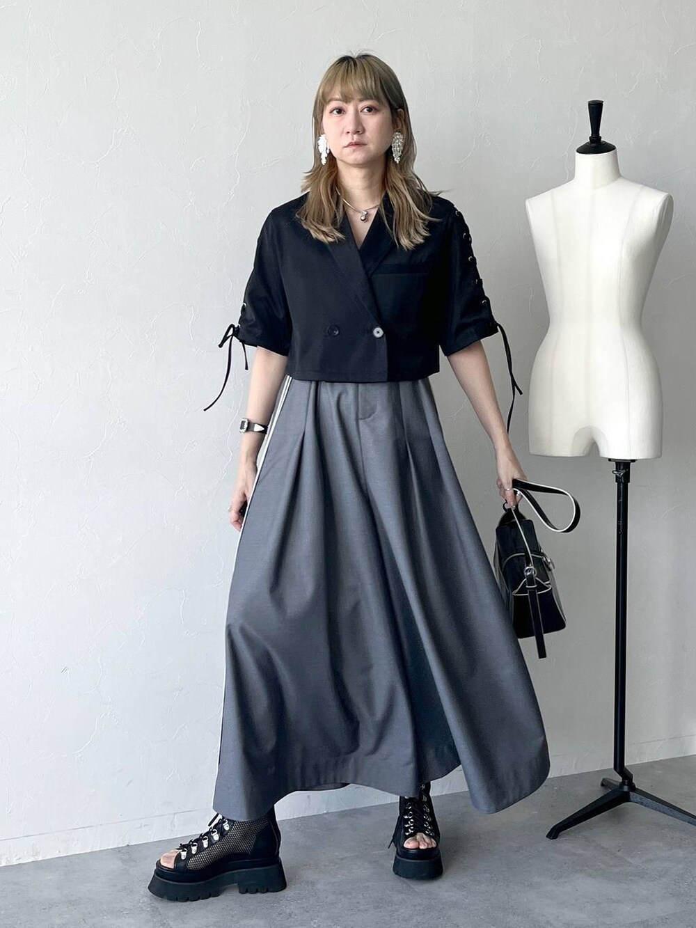 ブラック系のサンダル、グレー系のサロペット/オーバーオール、ブラック系のTシャツ/カットソーを着用したレディースの春コーディネートの2枚目の写真