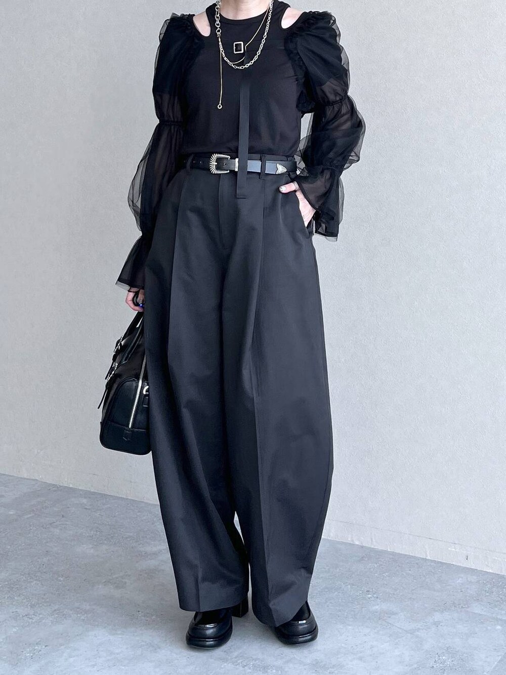 ブラック系のカーディガン/ボレロ、ブラック系のチノパンツ、ブラック系のTシャツ/カットソーを着用したレディースの夏コーディネートの3枚目の写真