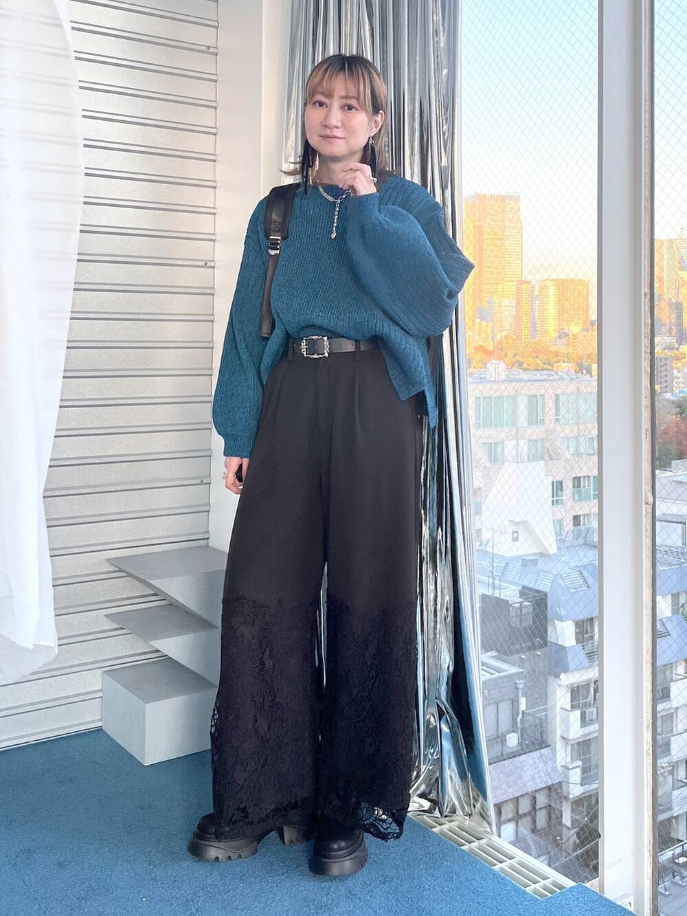 ブラック系のブーツ、ブルー系のニット/セーター、ブラック系のその他パンツを着用したレディースの冬コーディネートの9枚目の写真