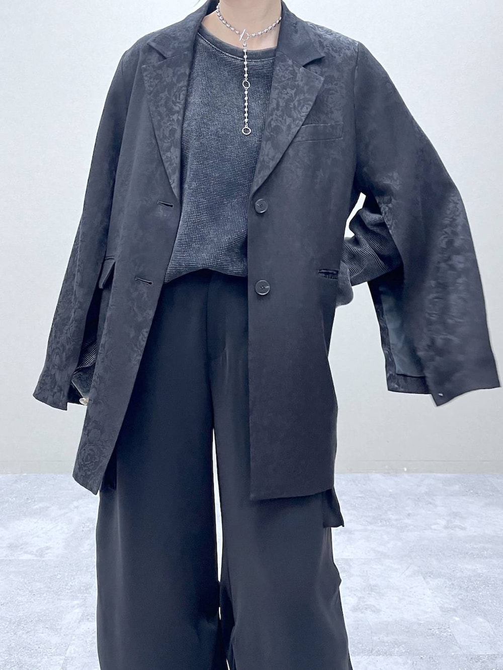 ブラック系のブーツ、ブラック系のテーラードジャケット、グレー系のTシャツ/カットソーを着用したレディースの冬コーディネートの3枚目の写真