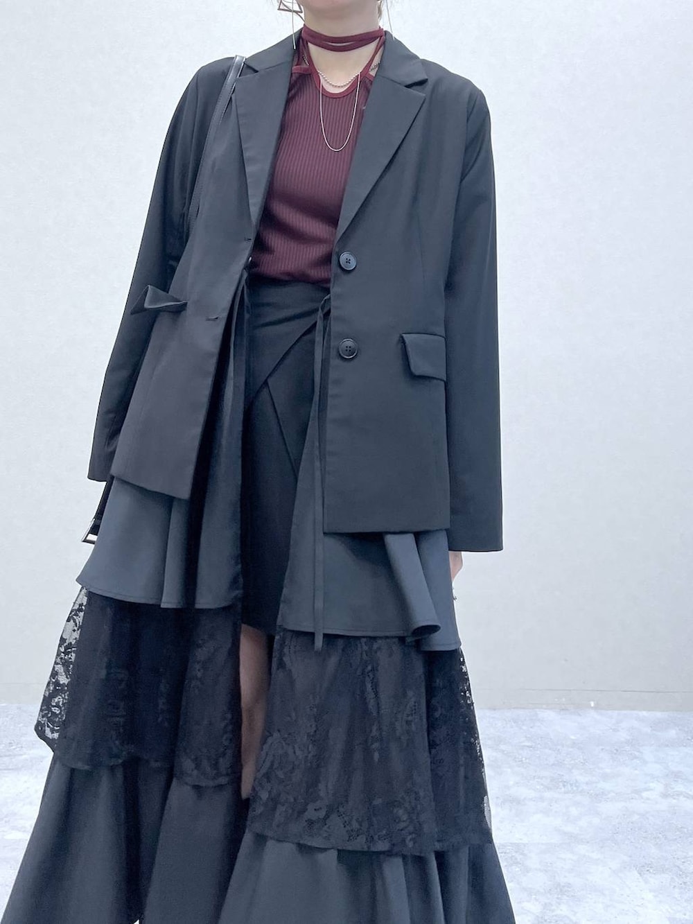 ブラック系のショルダーバッグ、その他のスカート、ブラック系のブーツを着用したレディースの秋コーディネートの3枚目の写真