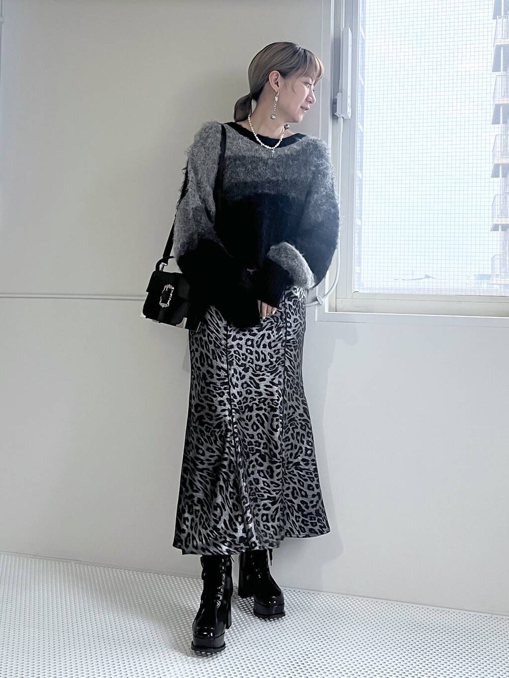 ブラック系のブーツ、ブラック系のショルダーバッグ、ブラック系のニット/セーターを着用したレディースの秋コーディネートの7枚目の写真