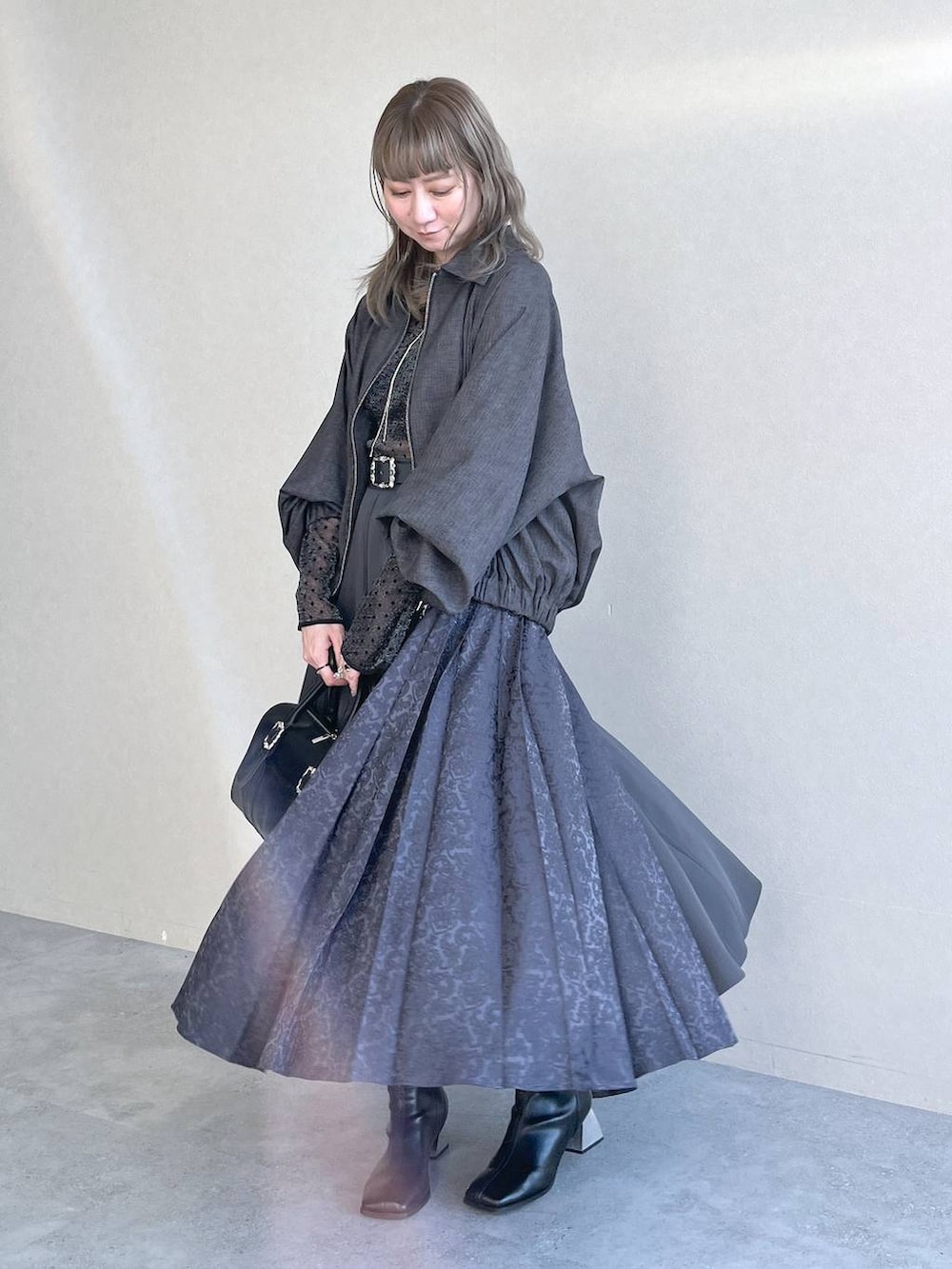 ブラック系のTシャツ/カットソー、ブラック系のボストンバッグ、ブラック系のブーツを着用したレディースの秋コーディネートの4枚目の写真